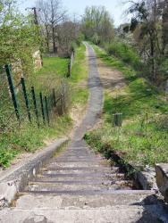 Portion de piste cyclable et escalier pour descendre du pont de la voie ferrée